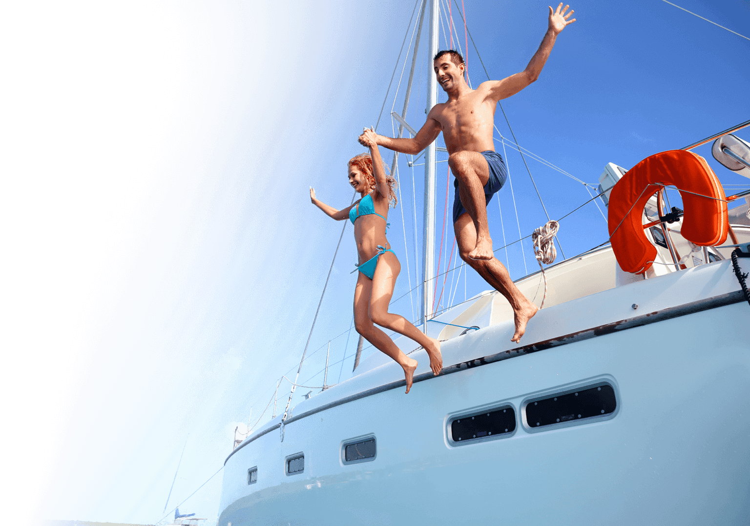 People jumping off their sailboat